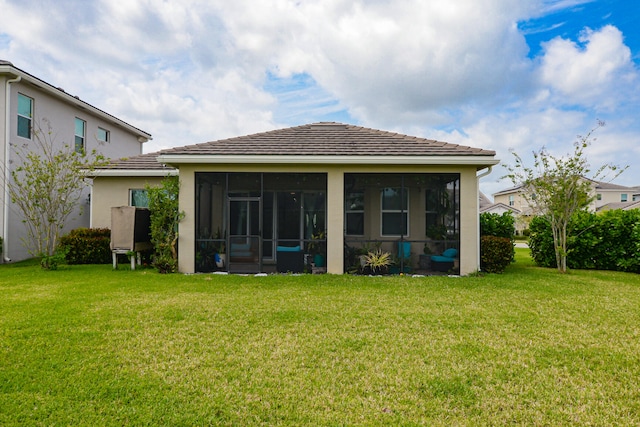 back of property featuring a sunroom and a yard