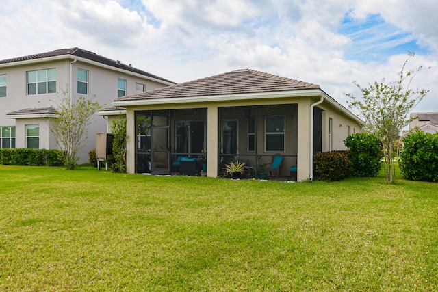 back of house with a yard and a sunroom