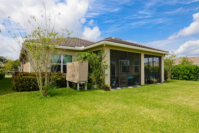 back of house featuring a yard and a sunroom