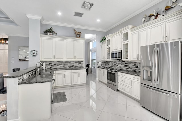 kitchen featuring dark stone counters, kitchen peninsula, tasteful backsplash, appliances with stainless steel finishes, and sink