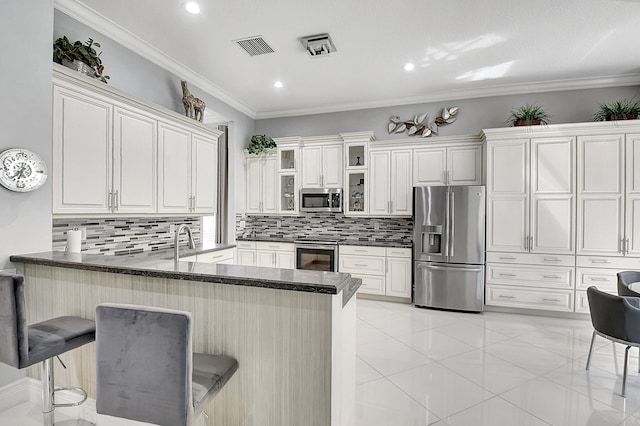 kitchen with kitchen peninsula, dark stone counters, a breakfast bar area, stainless steel appliances, and tasteful backsplash