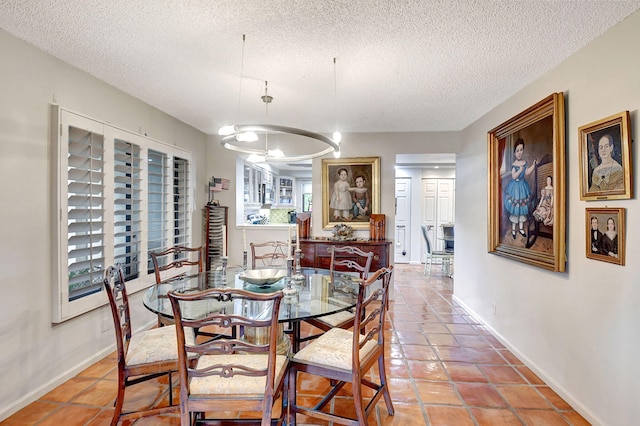 tiled dining room with a textured ceiling