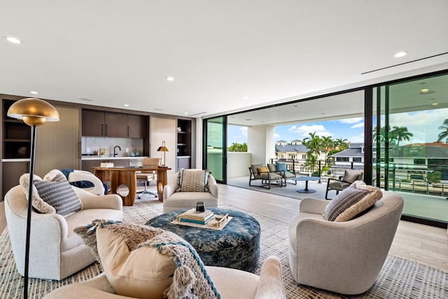 living area with recessed lighting, light wood finished floors, and expansive windows