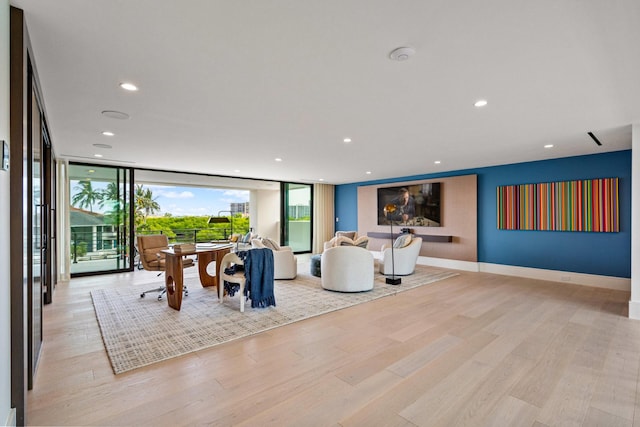 living area with recessed lighting, floor to ceiling windows, and light wood-type flooring