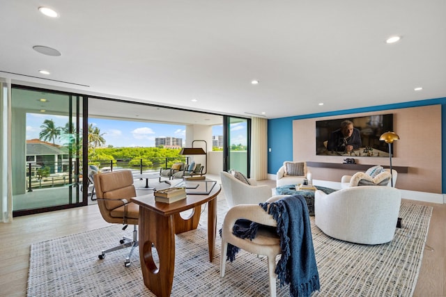 living room with floor to ceiling windows, recessed lighting, wood finished floors, and baseboards