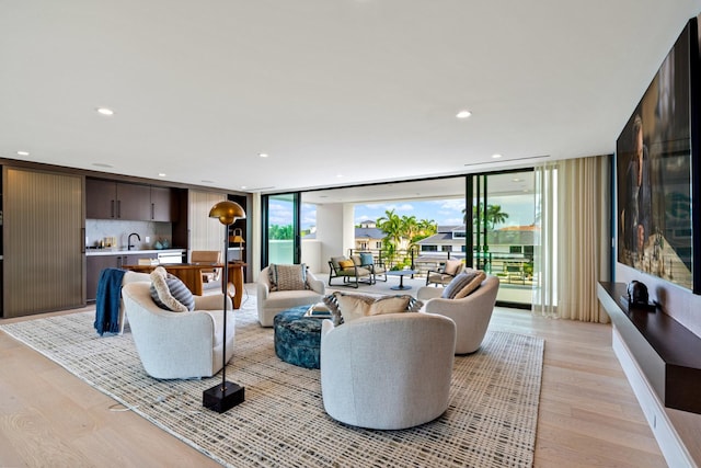 living area with recessed lighting, expansive windows, and light wood-style floors