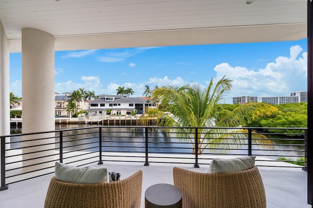 balcony featuring a residential view and a water view