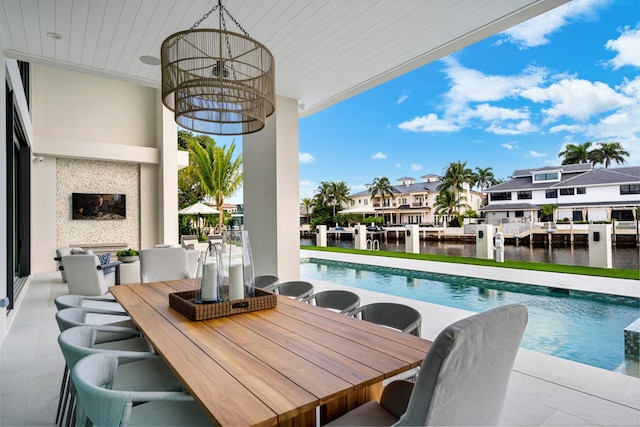 exterior space featuring a residential view, outdoor dining space, and a water view