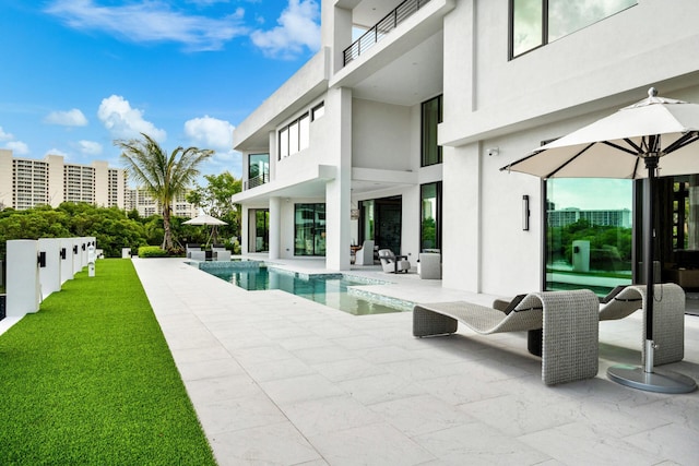 pool with a patio and a lawn