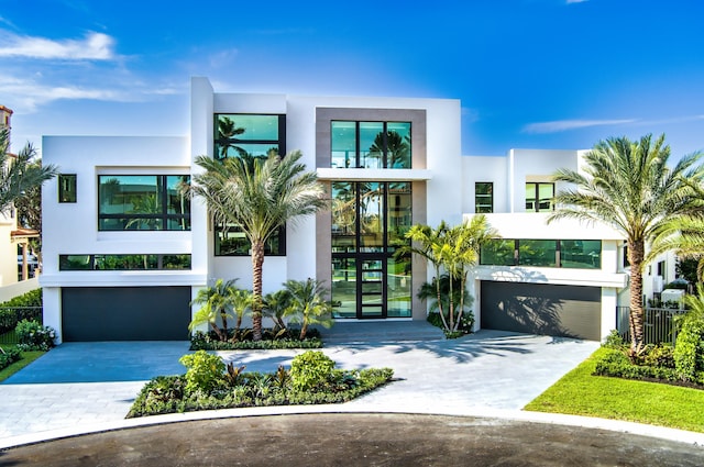 contemporary home featuring an attached garage, driveway, and stucco siding