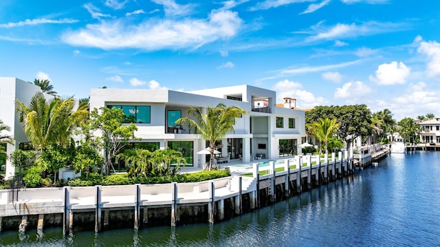 back of property with a water view and stucco siding