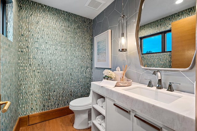 bathroom featuring toilet, vanity, decorative backsplash, tile walls, and hardwood / wood-style flooring