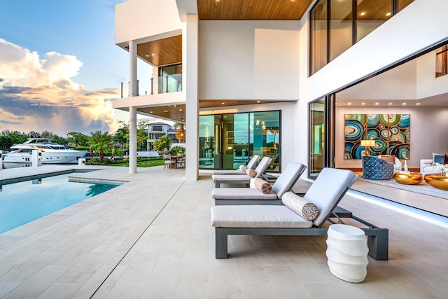 pool at dusk featuring a patio area