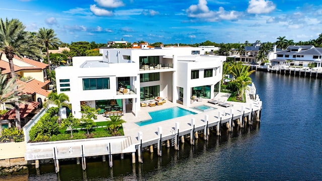 rear view of house with a balcony, a patio, and a water view