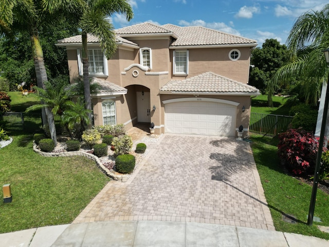 mediterranean / spanish house with a garage and a front yard