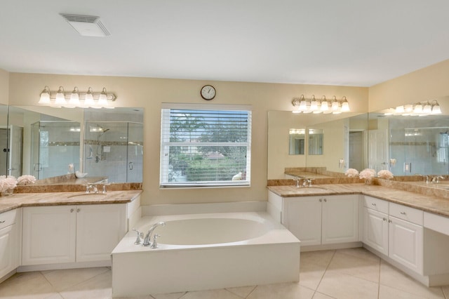 bathroom with vanity with extensive cabinet space, shower with separate bathtub, and tile floors