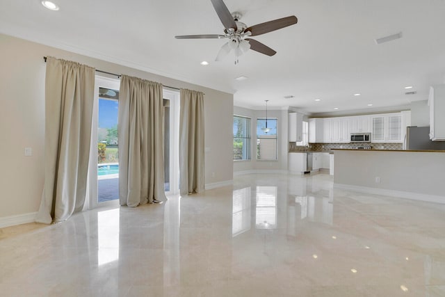 unfurnished living room featuring a wealth of natural light and ceiling fan