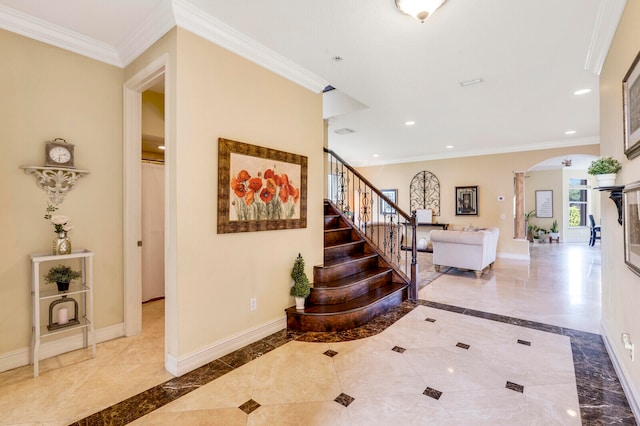 foyer entrance with light tile floors and ornamental molding