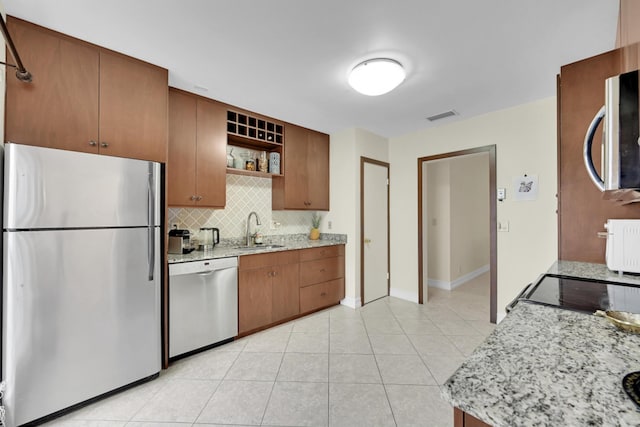 kitchen with backsplash, stainless steel appliances, sink, and light tile floors