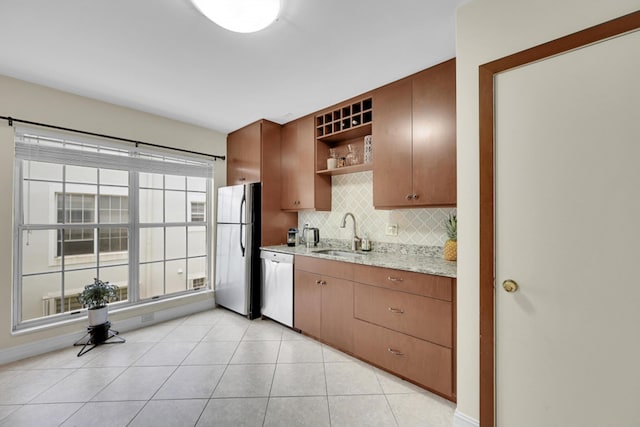 kitchen with stainless steel fridge, light tile flooring, sink, dishwasher, and tasteful backsplash