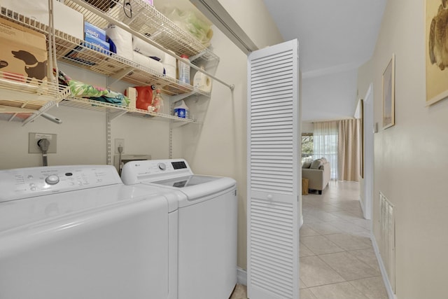 washroom featuring washing machine and clothes dryer, washer hookup, hookup for an electric dryer, and light tile flooring