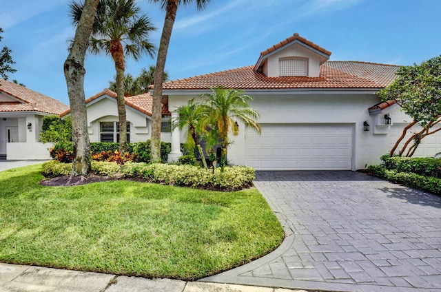 mediterranean / spanish-style house featuring a front lawn and a garage