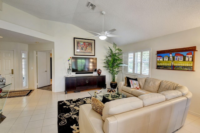 tiled living room featuring lofted ceiling, a textured ceiling, and ceiling fan