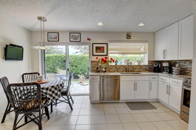 kitchen with sink, stainless steel appliances, white cabinetry, and a wealth of natural light