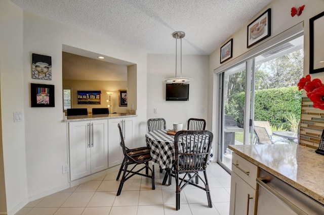 tiled dining room featuring a textured ceiling