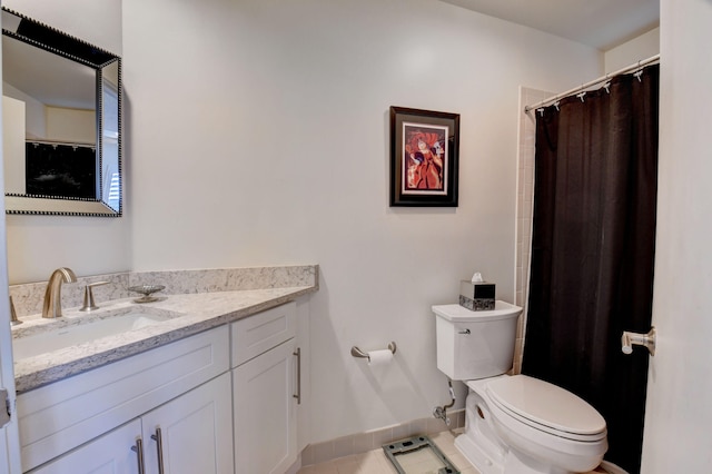 bathroom with tile floors, vanity with extensive cabinet space, and toilet