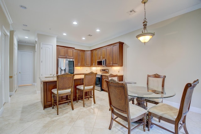 kitchen with pendant lighting, light tile patterned floors, light stone countertops, ornamental molding, and appliances with stainless steel finishes