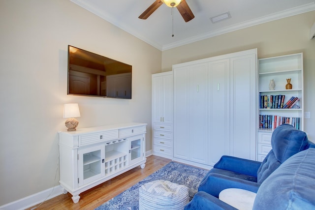 living room featuring light wood-type flooring, ceiling fan, and crown molding