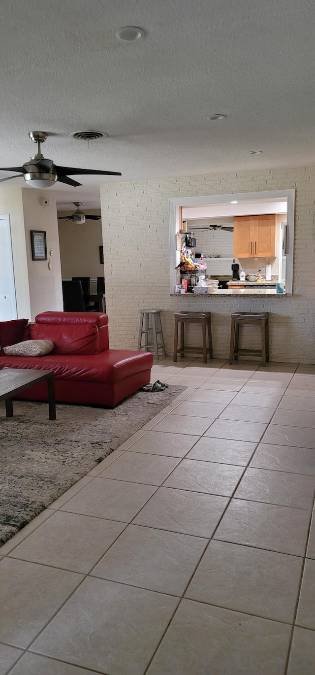 bathroom with a textured ceiling, ceiling fan, and tile flooring