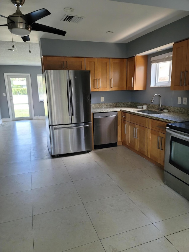 kitchen featuring sink, ceiling fan, light tile flooring, and stainless steel appliances