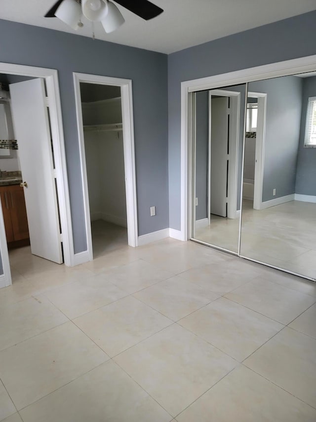 unfurnished bedroom featuring connected bathroom, ceiling fan, and light tile floors