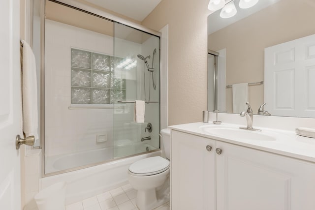 full bathroom featuring enclosed tub / shower combo, toilet, vanity with extensive cabinet space, and tile flooring