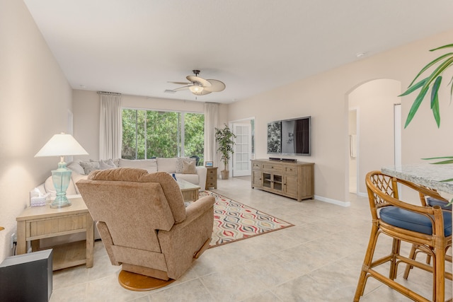 tiled living room with ceiling fan