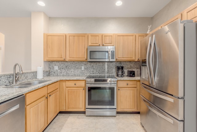 kitchen with light brown cabinetry, light tile flooring, appliances with stainless steel finishes, and sink