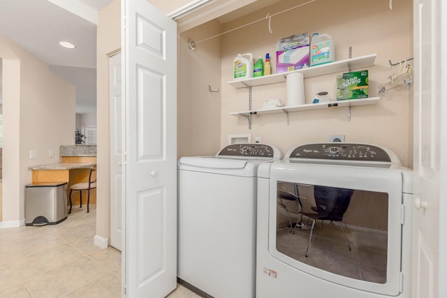 washroom with light tile floors and washing machine and dryer