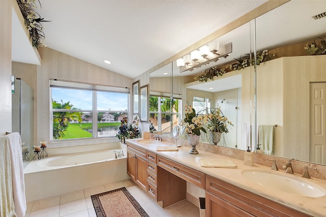 bathroom with a bathing tub, vanity, tile patterned flooring, vaulted ceiling, and a water view