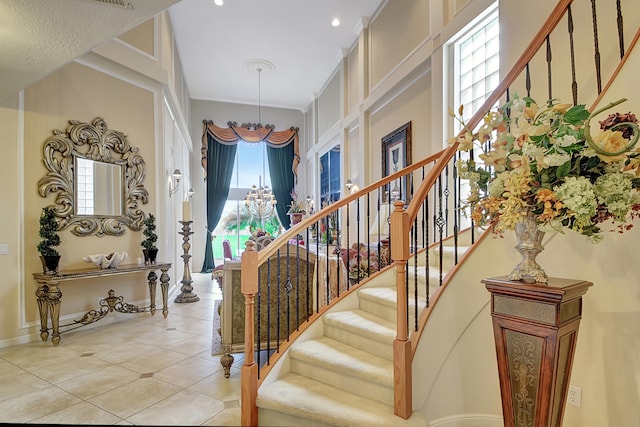 staircase with tile patterned flooring and a notable chandelier