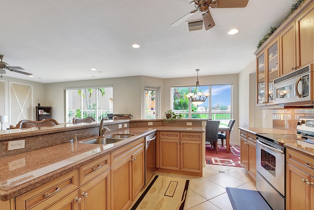 kitchen featuring ceiling fan with notable chandelier, stainless steel appliances, sink, light tile patterned floors, and hanging light fixtures