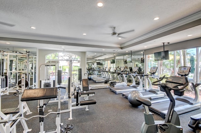 exercise room with a textured ceiling, ceiling fan, and ornamental molding