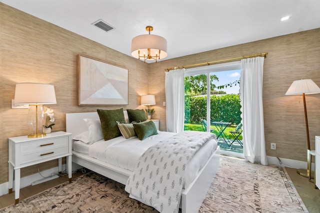 bedroom featuring a chandelier and access to outside