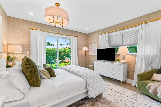 bedroom featuring an inviting chandelier and access to outside