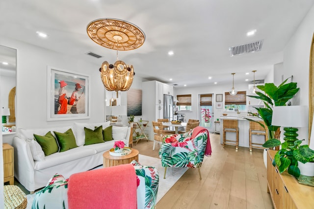 living room with light hardwood / wood-style flooring and an inviting chandelier