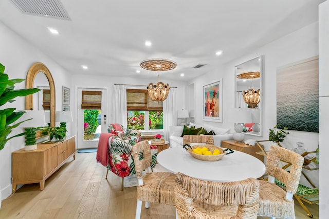 interior space featuring an inviting chandelier and light hardwood / wood-style flooring