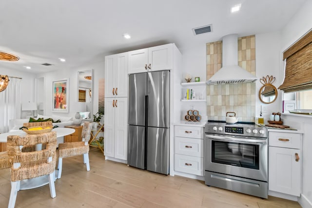 kitchen with backsplash, appliances with stainless steel finishes, custom exhaust hood, light hardwood / wood-style floors, and white cabinets