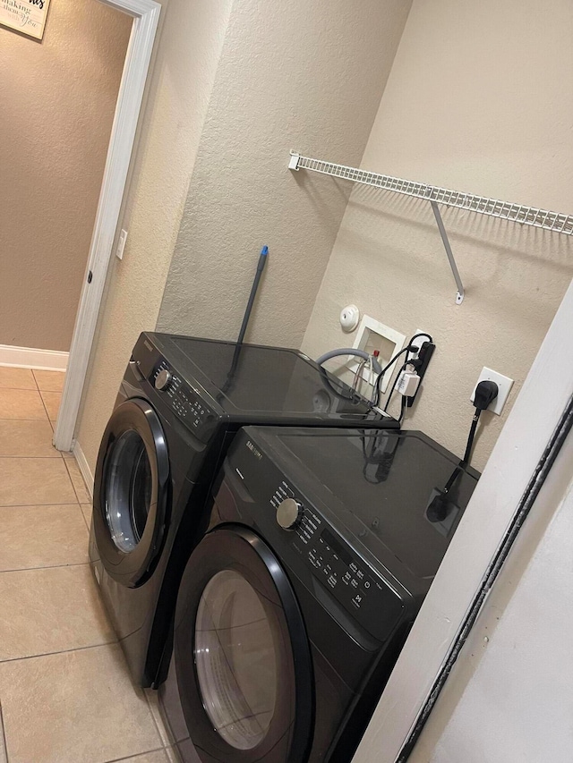 laundry area featuring light tile floors, washer and clothes dryer, hookup for an electric dryer, and washer hookup