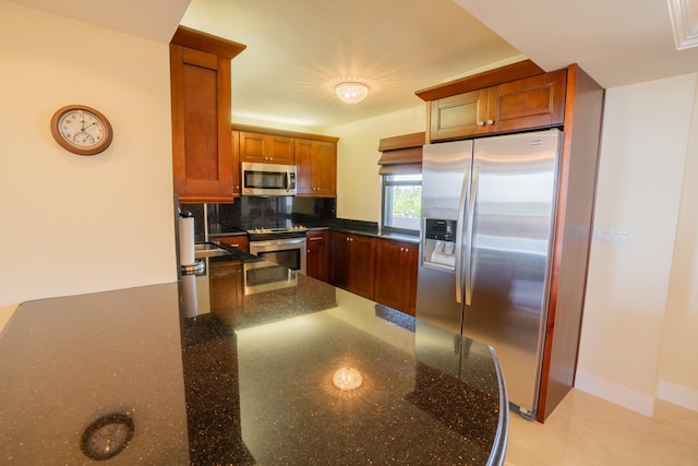 kitchen featuring decorative backsplash, dark stone countertops, and stainless steel appliances